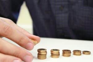 Senior money management elderly person hand organizing gold coins money into stacks